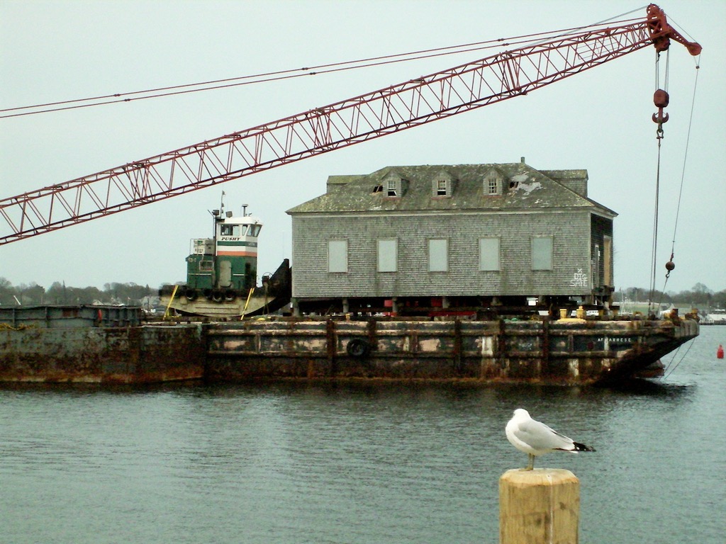 Barge with crane and building on it.