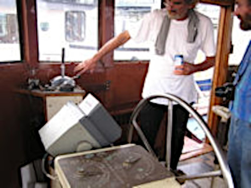 mand at wheel of tugboat